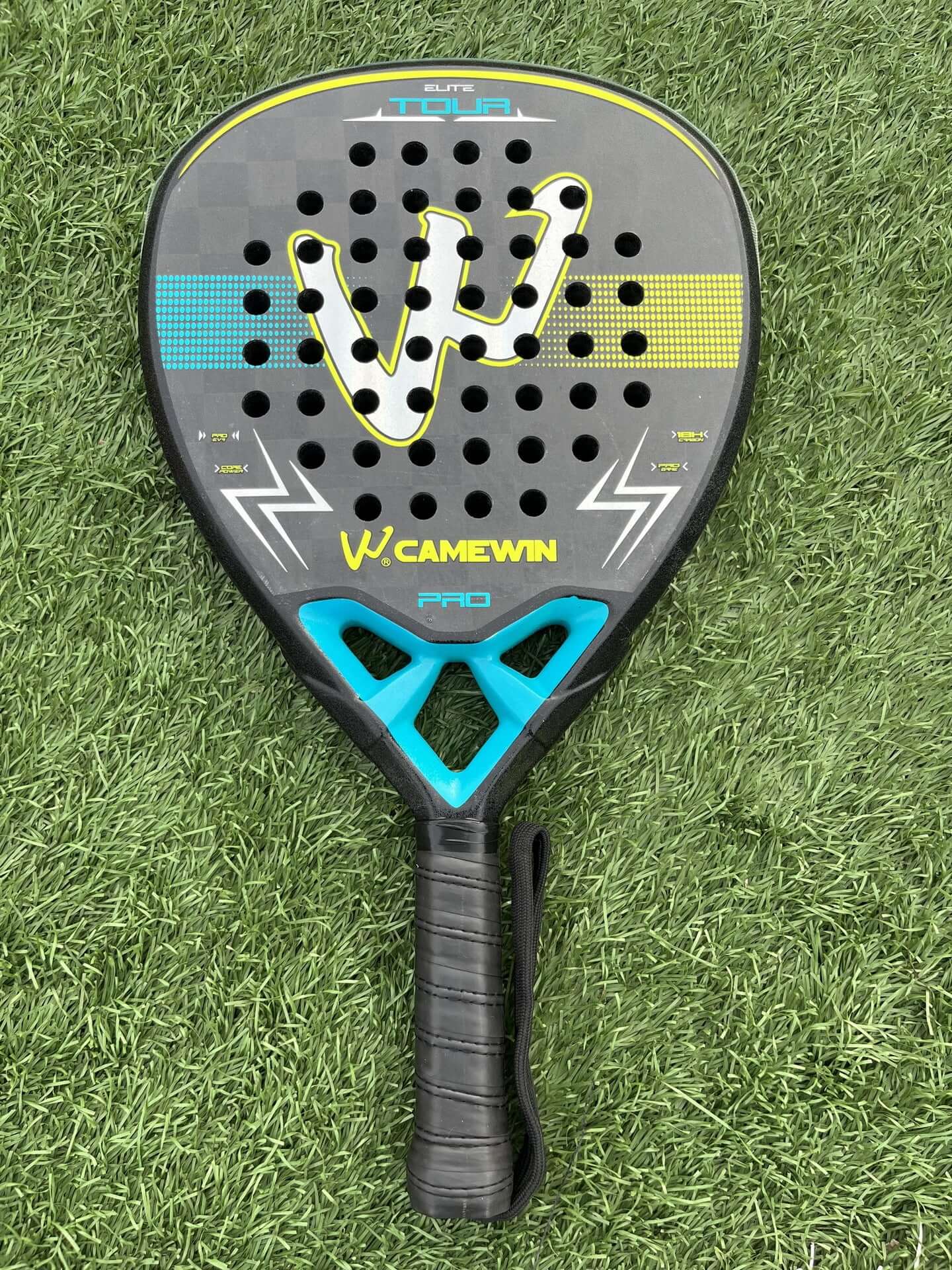 18K Transparent Carbon Tennis Rackets on green grass background, showcasing its bold design and paddle features.