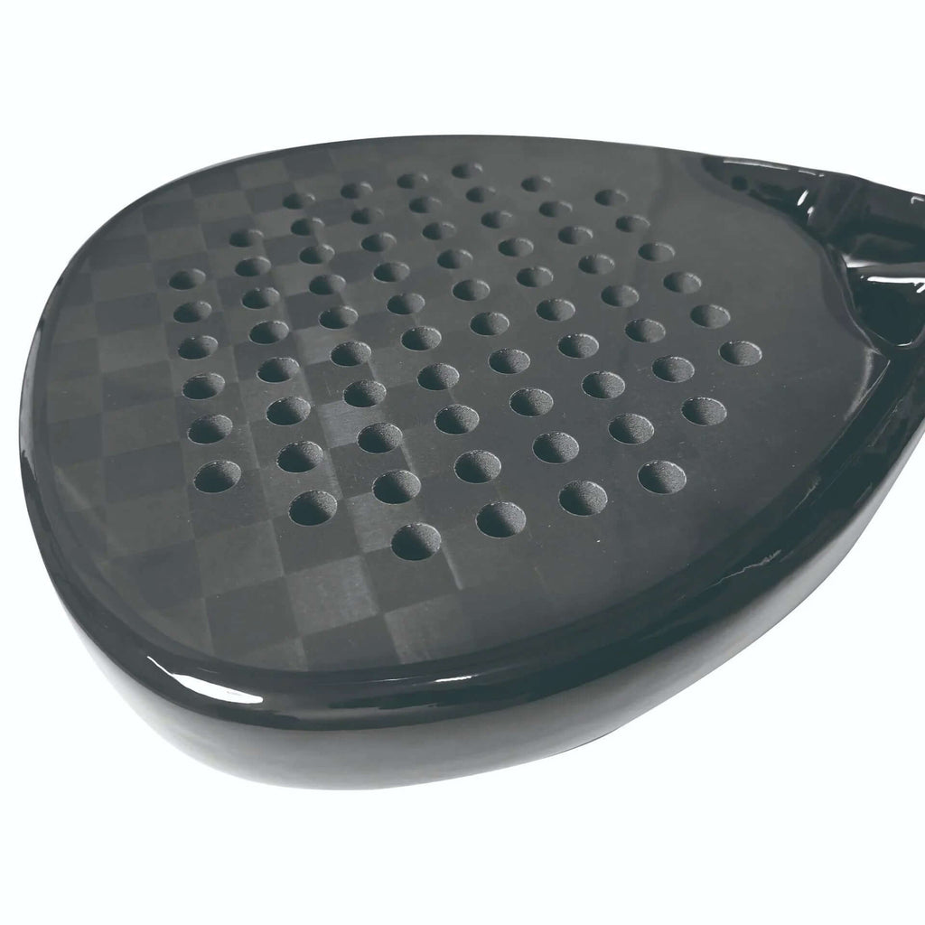 Close-up of the face of the best carbon fiber padel racket, showcasing its textured surface and perforations for optimal control.