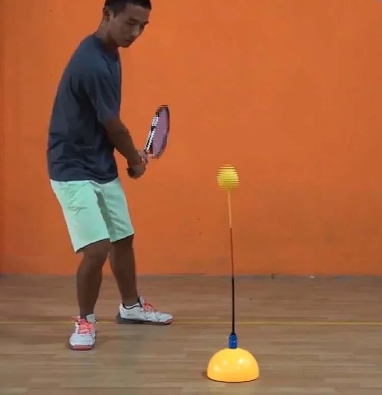 Player practicing with portable tennis trainer, improving skills with rebound training tool.