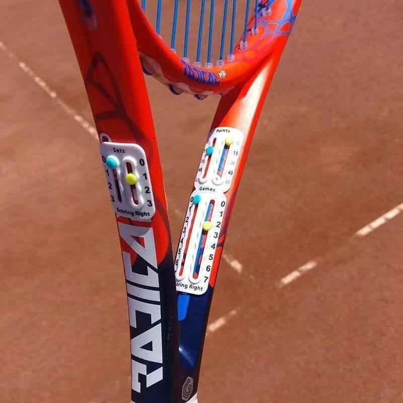 Tennis racket accessories scorer displayed on a red and blue tennis racket, showcasing training tools for improved precision.