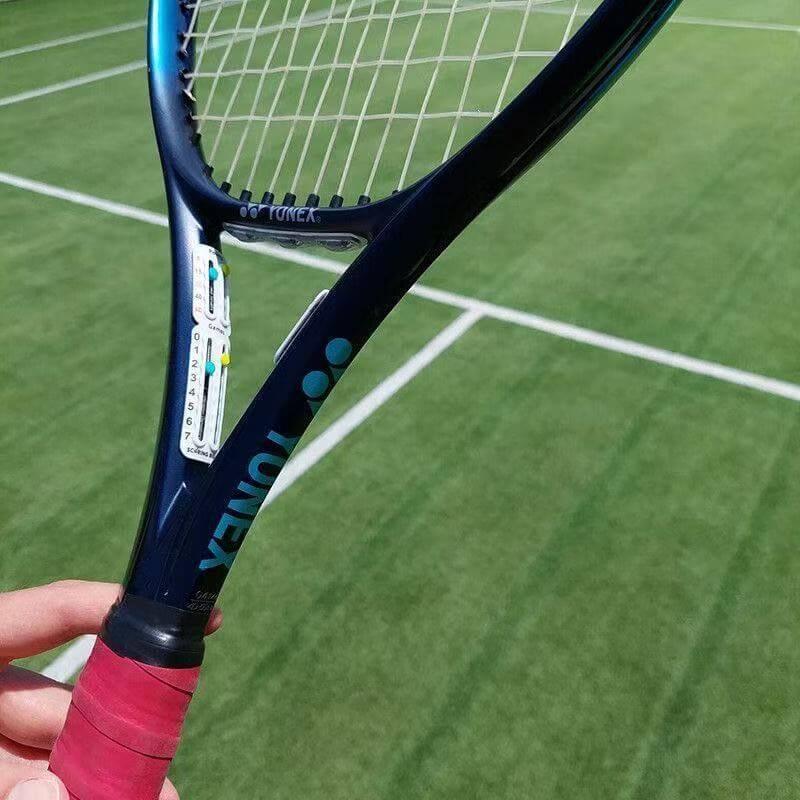 Tennis racket accessories scorer in hand on a tennis court surface, enhancing training for players.