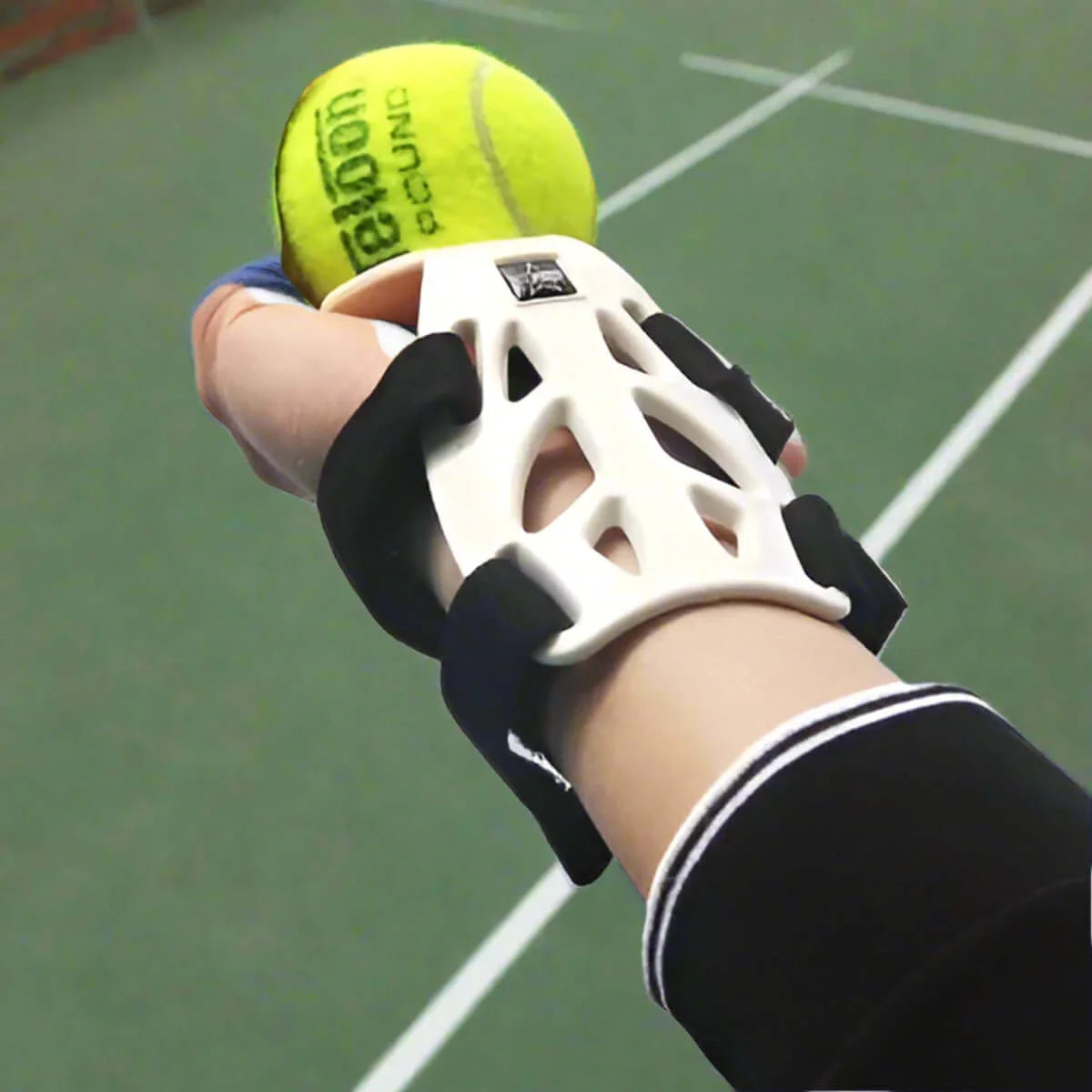 Wrist guard support for tennis on a hand holding a green tennis ball, designed for comfort and injury prevention.
